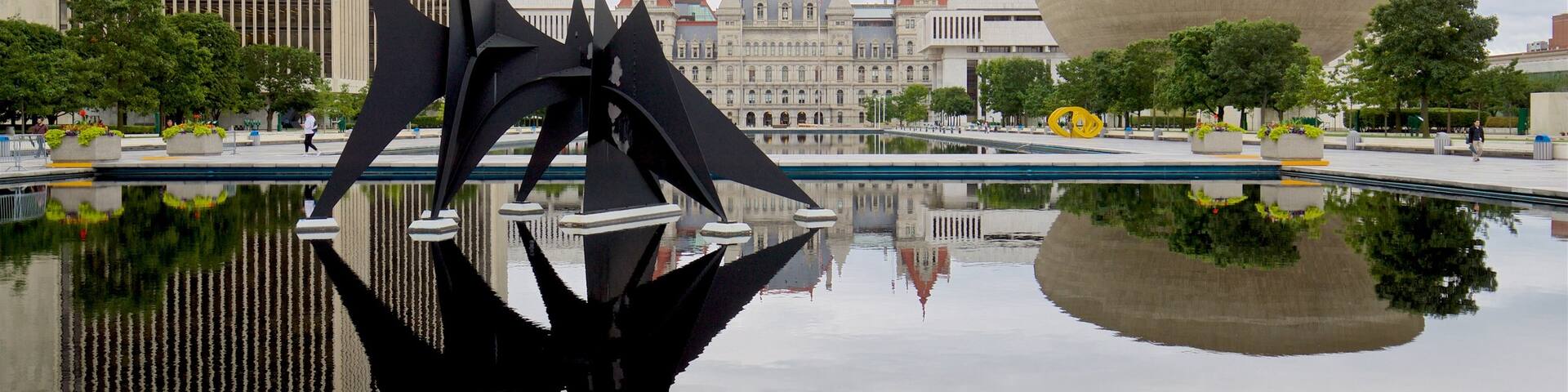 Governor Nelson A. Rockefeller Empire State Plaza showing outdoor art, a pond and modern architecture