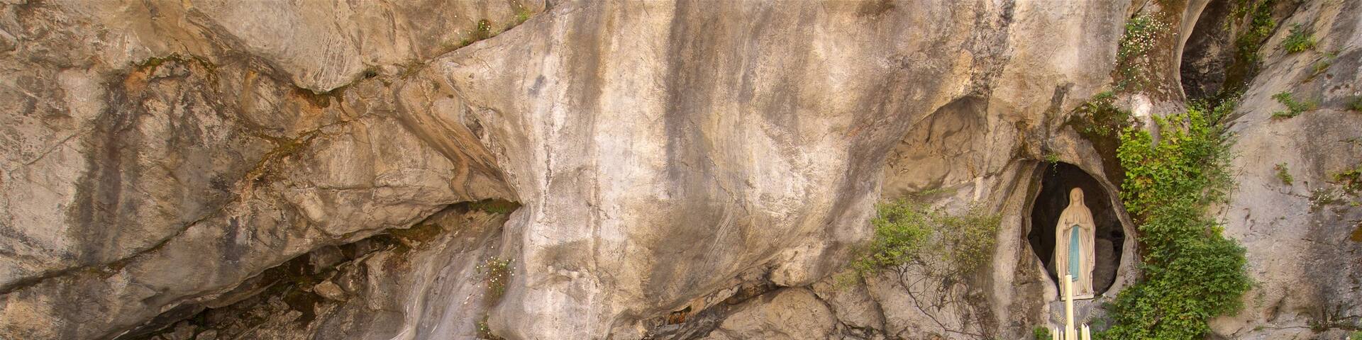 Grotte of Massabielle which includes religious aspects as well as a small group of people
