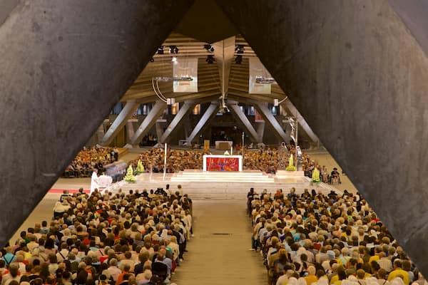 Basilique Saint-Pie X montrant vues intérieures et église ou cathédrale aussi bien que important groupe de personnes