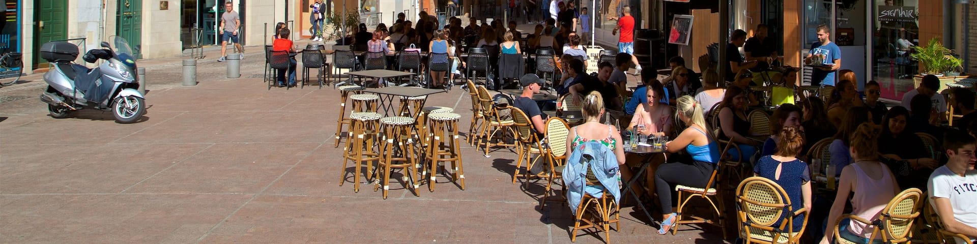 Esquirol Place showing a city and outdoor eating as well as a small group of people