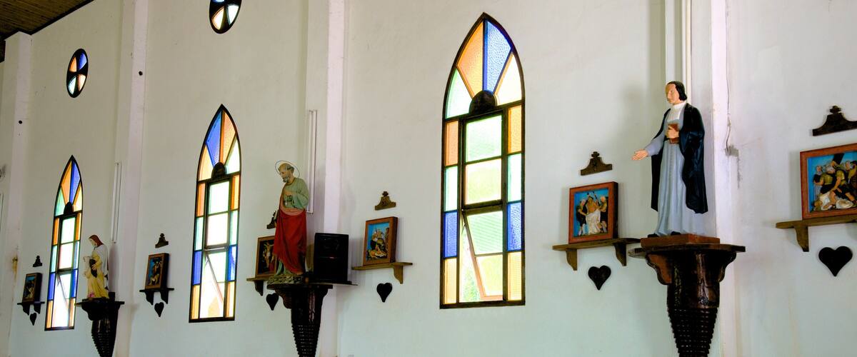 Isle of Pines featuring interior views and a church or cathedral as well as a small group of people
