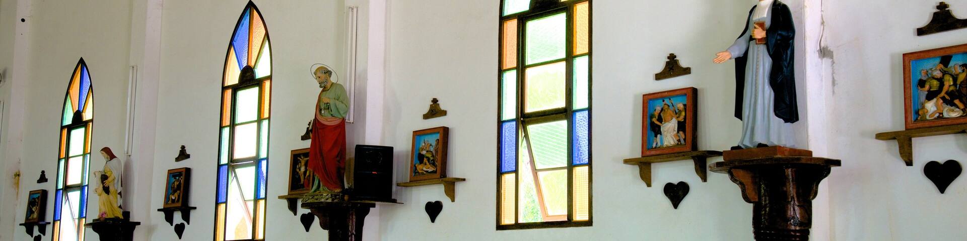 Isle of Pines featuring interior views and a church or cathedral as well as a small group of people