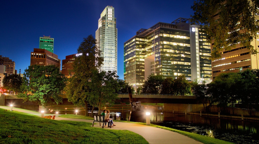 Omaha ofreciendo un edificio de gran altura, un río o arroyo y escenas nocturnas