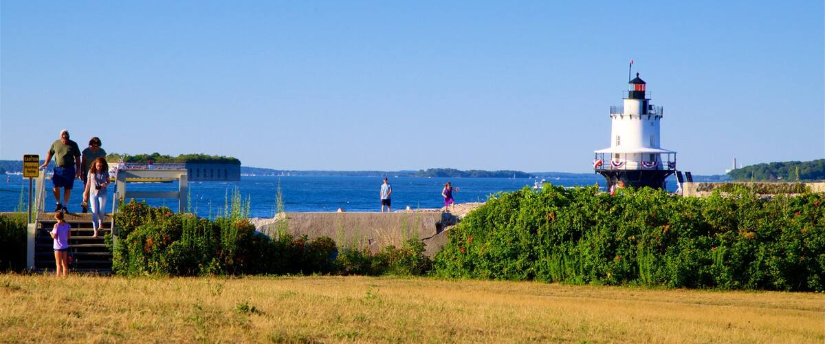 Fort Preble showing a lighthouse and a garden as well as a small group of people
