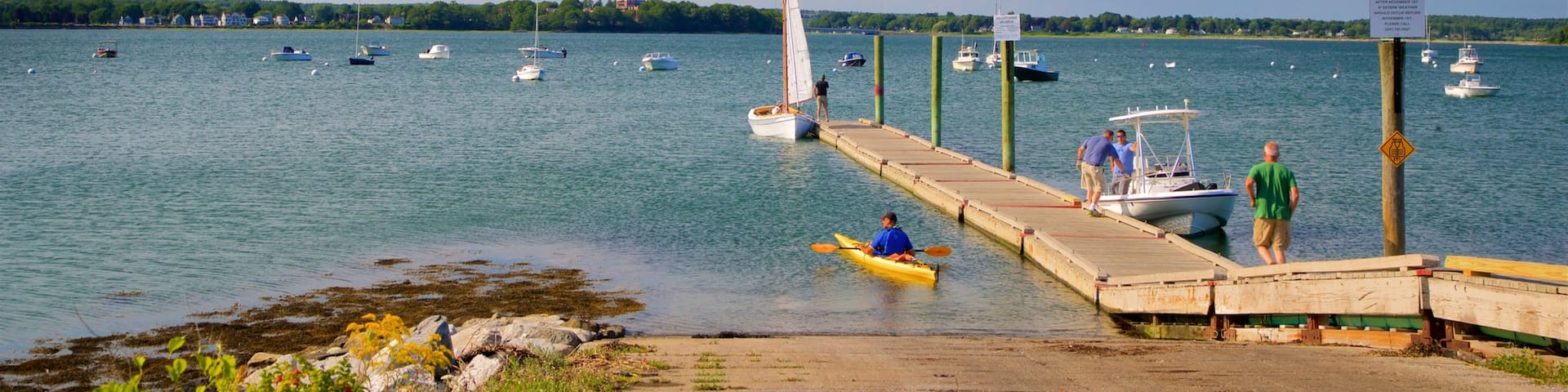 Eastern Promenade showing a bay or harbor and general coastal views as well as a small group of people