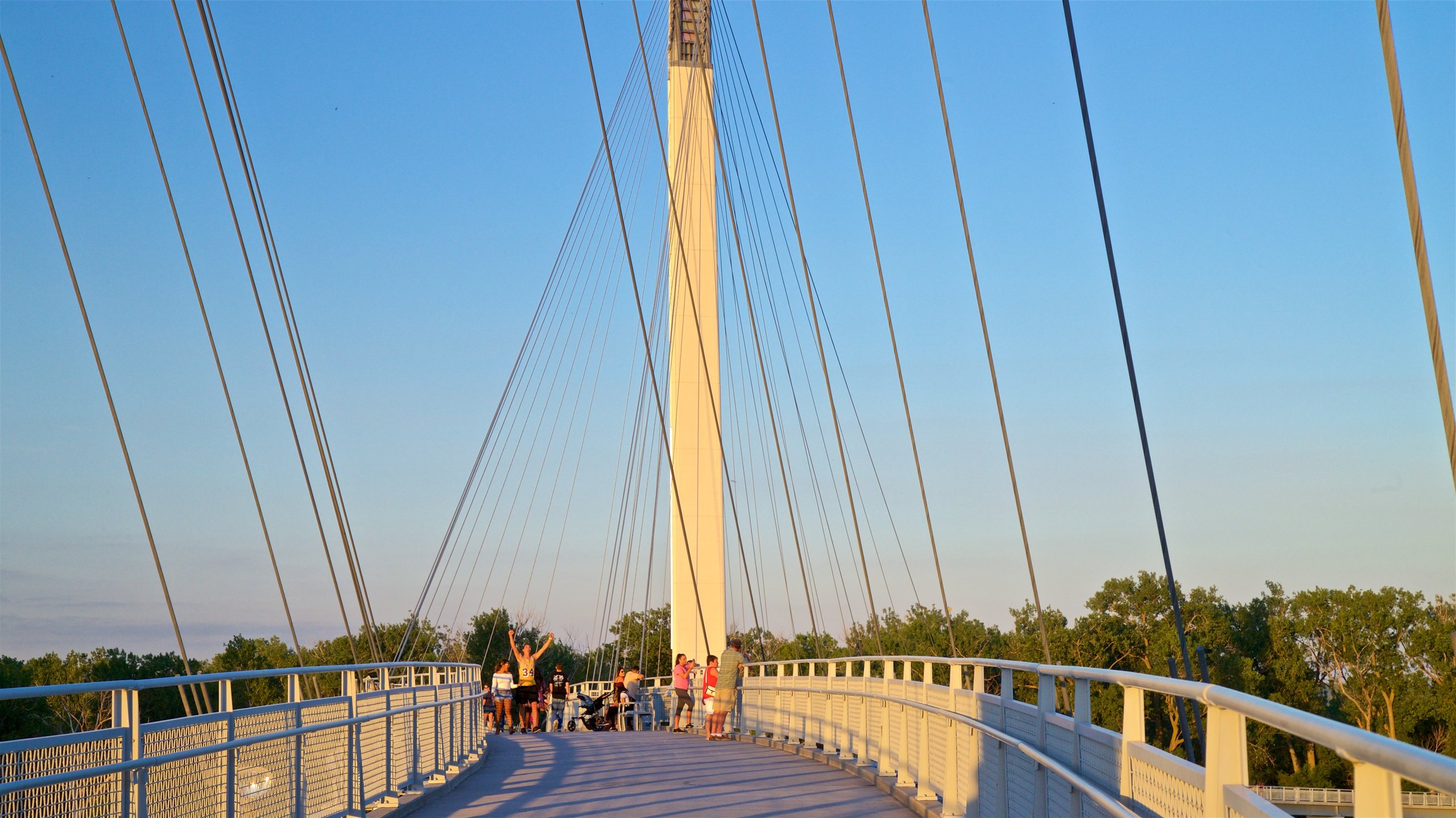 Bob Kerrey Pedestrian Bridge showing a sunset and a bridge as well as a small group of people