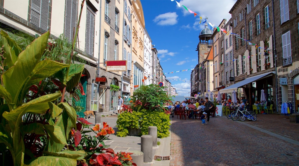 Riom che include città e mangiare all\'aperto cosi come un piccolo gruppo di persone