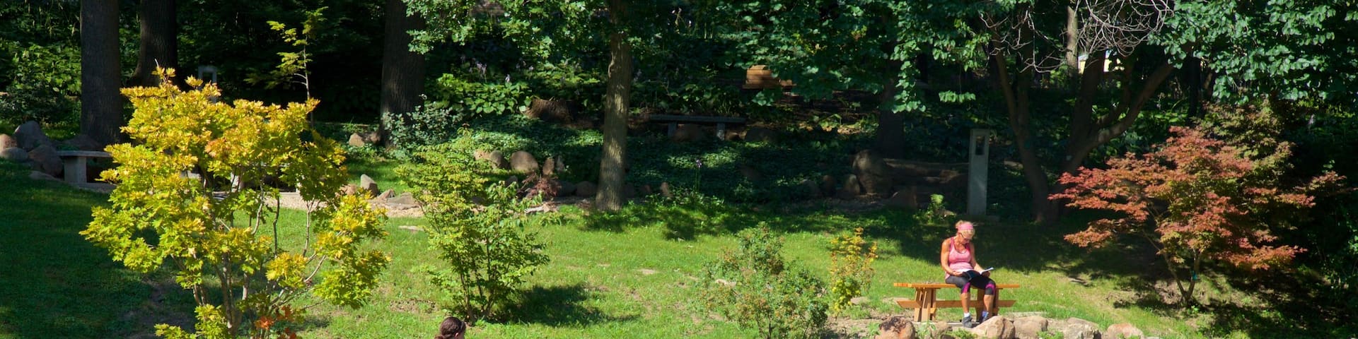 Dubuque Arboretum and Botanical Gardens featuring a pond and a garden as well as an individual female