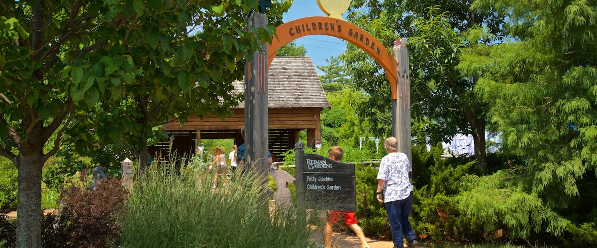 Reiman Gardens featuring signage and a park as well as a family