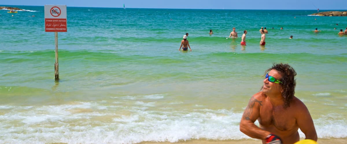 Tel Aviv showing general coastal views and a beach as well as an individual male