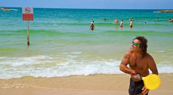 Tel Aviv som inkluderar en sandstrand och kustutsikter såväl som en man