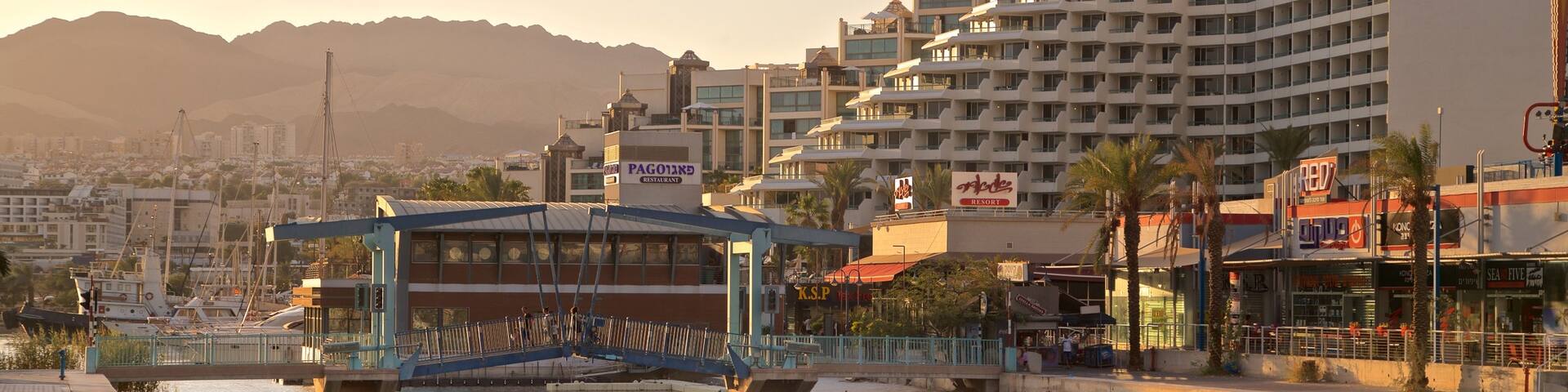 Eilat Marina featuring a river or creek, a bridge and a sunset