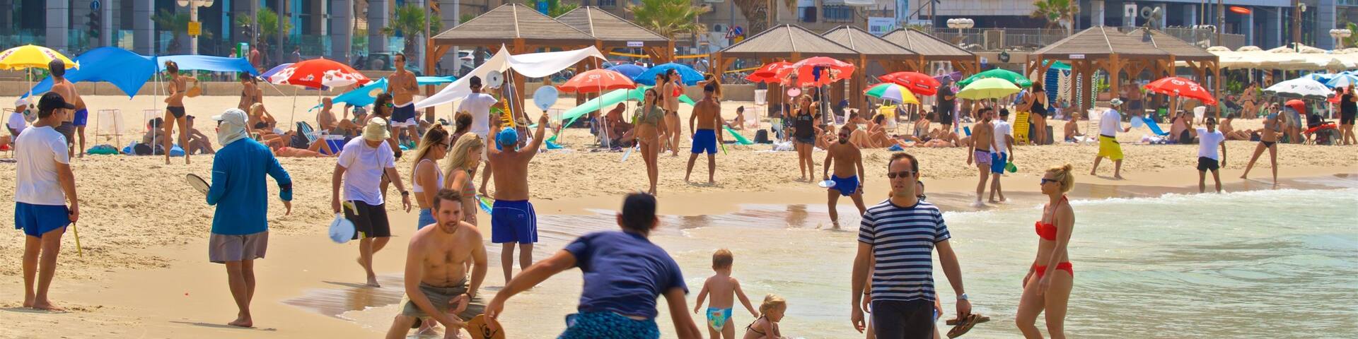 Tel Aviv showing a sandy beach, swimming and a coastal town