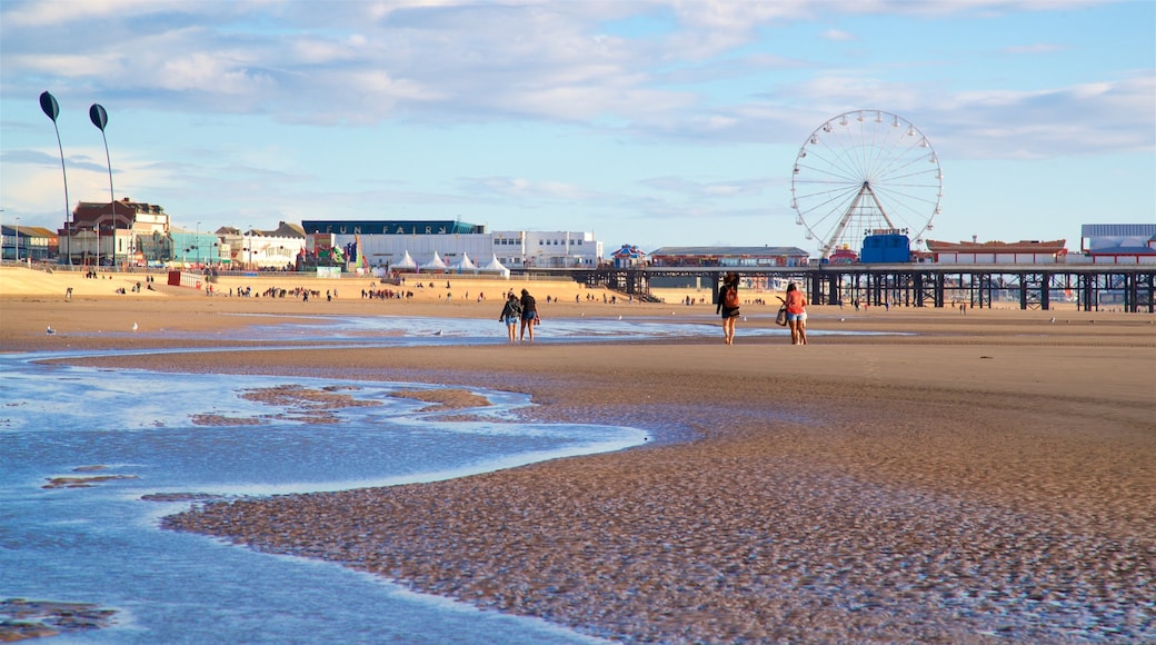 Blackpool Central Pier which includes a sandy beach and general coastal views as well as a small group of people