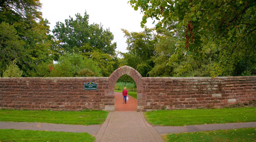 Grappenhall Heys Walled Garden caracterizando um jardim e elementos de patrimĂŽnio assim como uma mulher sozinha