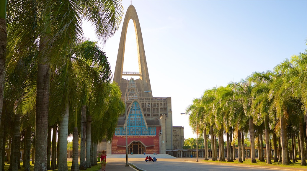 La Altagracia Cathedral showing a sunset and modern architecture as well as a small group of people