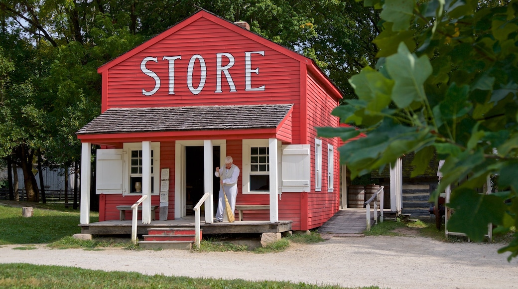 Conner Prairie Interactive History Park which includes a small town or village and signage as well as an individual male