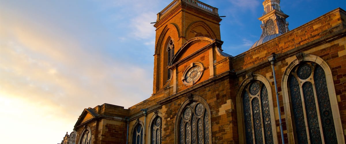 All Saints Church featuring heritage architecture and a sunset