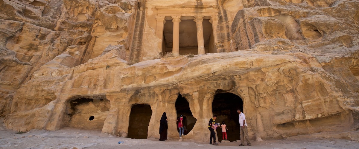 Little Petra featuring a gorge or canyon and heritage architecture as well as a small group of people