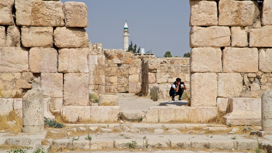 Ciudadela de Amán ofreciendo elementos del patrimonio y ruinas de edificios y también un hombre