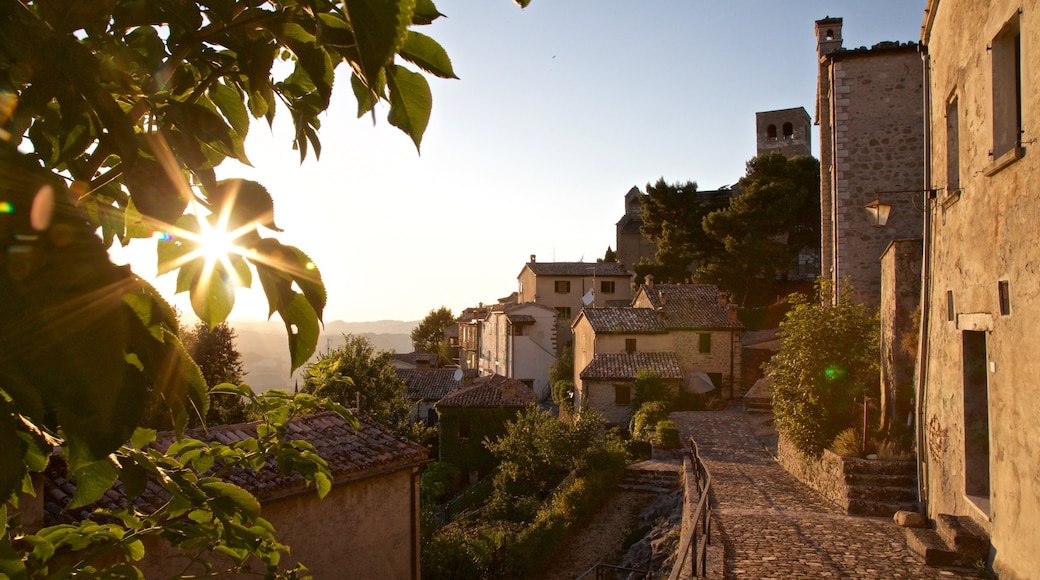 San Leo mostrando una pequeña ciudad o aldea y un atardecer