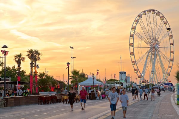 Grande Roue Rimini Ferris Wheel montrant coucher de soleil aussi bien que petit groupe de personnes