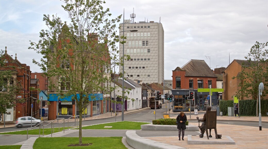 Stoke-on-Trent som visar en staty eller skulptur och en stad såväl som en kvinna