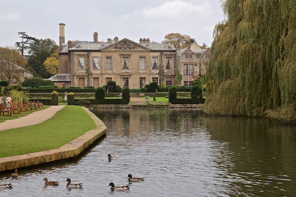 Coombe Abbey Country Park das einen historische Architektur, Teich und Haus