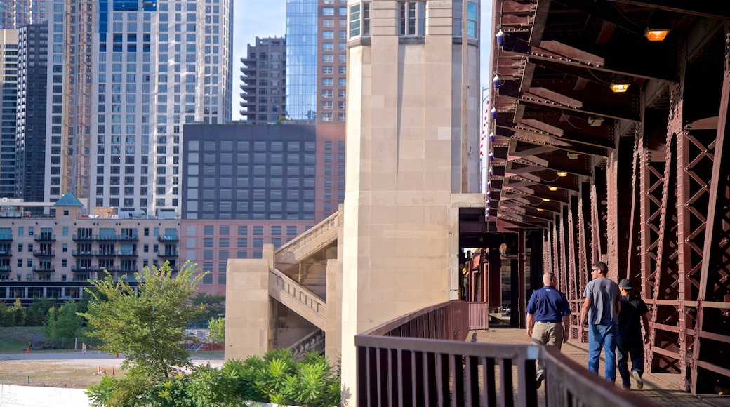 Chicago Riverwalk which includes a bridge and a city as well as a small group of people