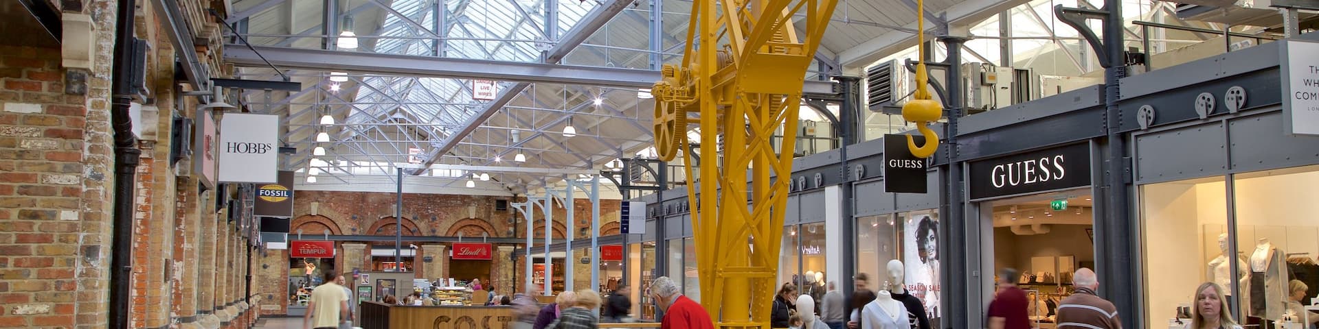 Swindon Designer Outlet featuring interior views and shopping as well as a small group of people