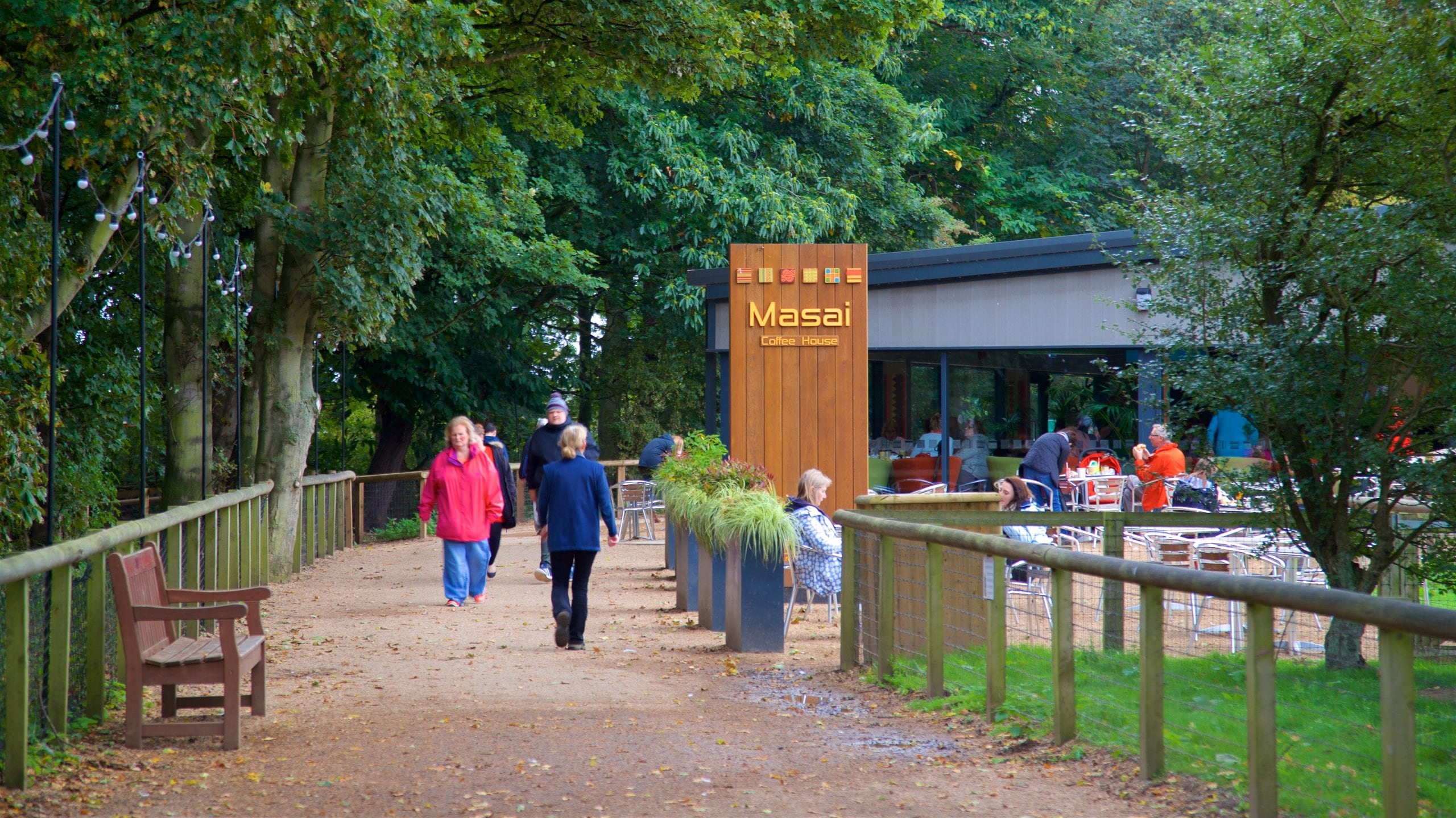 Yorkshire Wildlife Park johon kuuluu kyltit ja puisto sekä pieni ryhmä ihmisiä