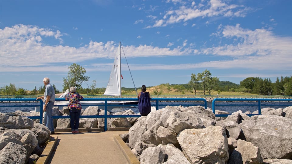 Muskegon featuring a bay or harbour as well as a small group of people