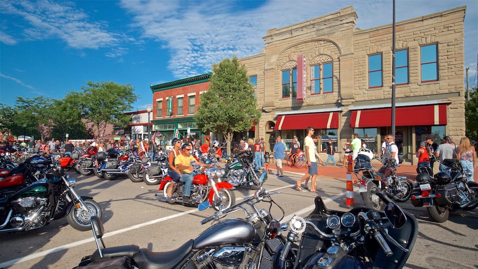 Muskegon featuring motorbike riding and street scenes as well as a large group of people