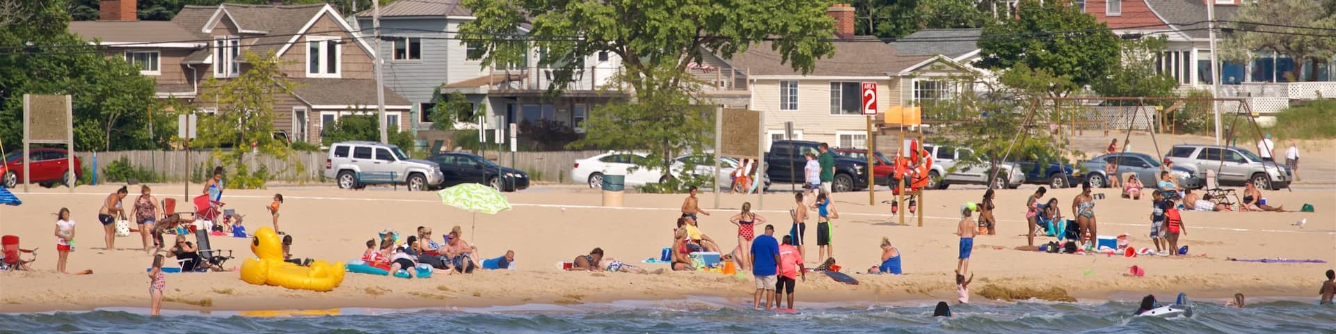 Pere Marquette Park Beach featuring general coastal views and a beach as well as a large group of people