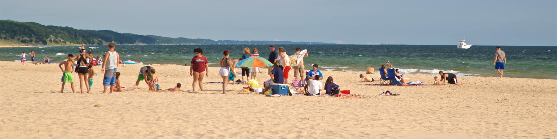 Pere Marquette Park Beach showing a sandy beach and general coastal views as well as a small group of people