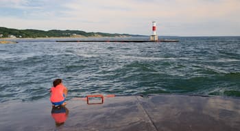 Holland das einen Leuchtturm und allgemeine Küstenansicht sowie einzelnes Kind