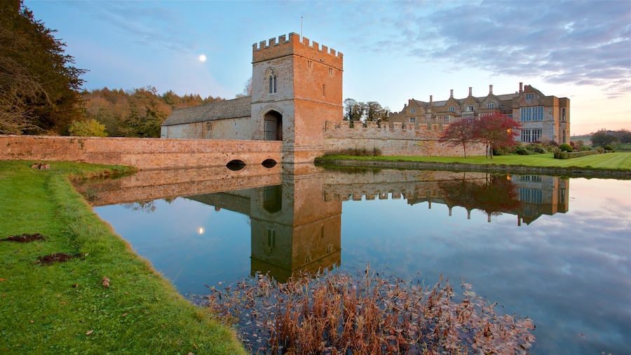 Broughton Castle which includes château or palace, a sunset and a lake or waterhole
