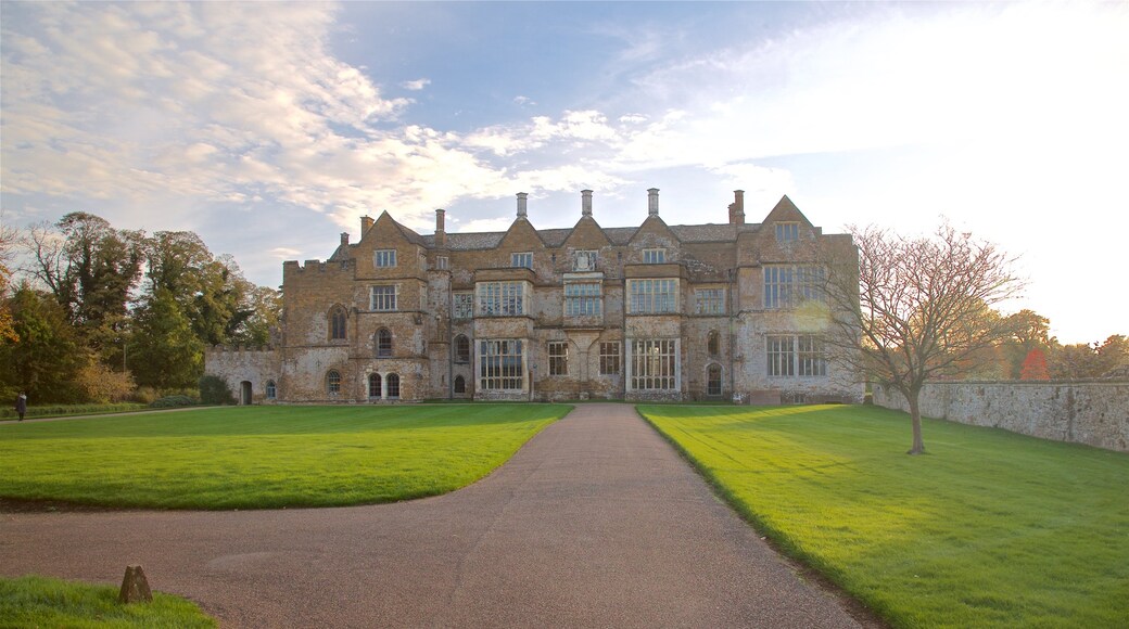 Broughton Castle som inkluderar historisk arkitektur och en solnedgång