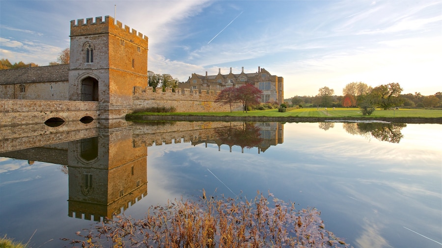 Broughton Castle som visar en sjö eller ett vattenhål, en solnedgång och historisk arkitektur