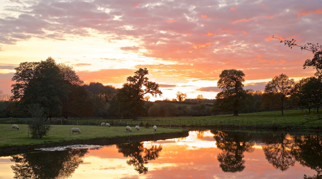 Broughton Castle som inkluderar åkrar, en å eller flod och landskap