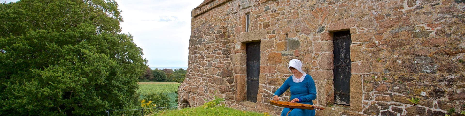 La Hougue Bie showing a house and heritage elements as well as an individual femail