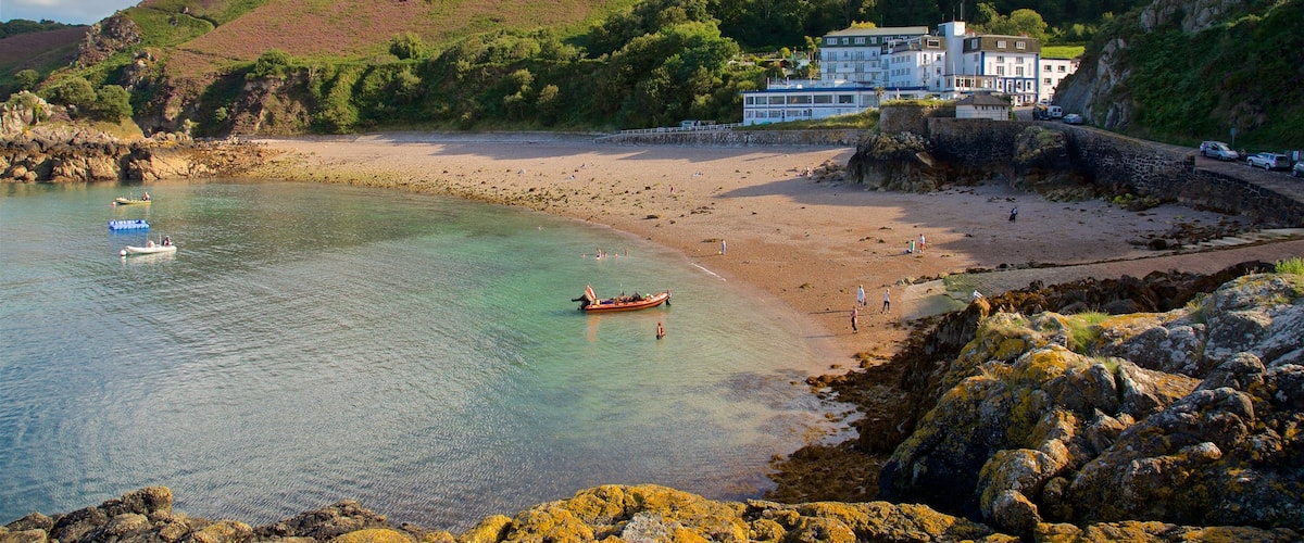 Bahía de Bouley que incluye una casa, una playa de arena y vistas generales de la costa