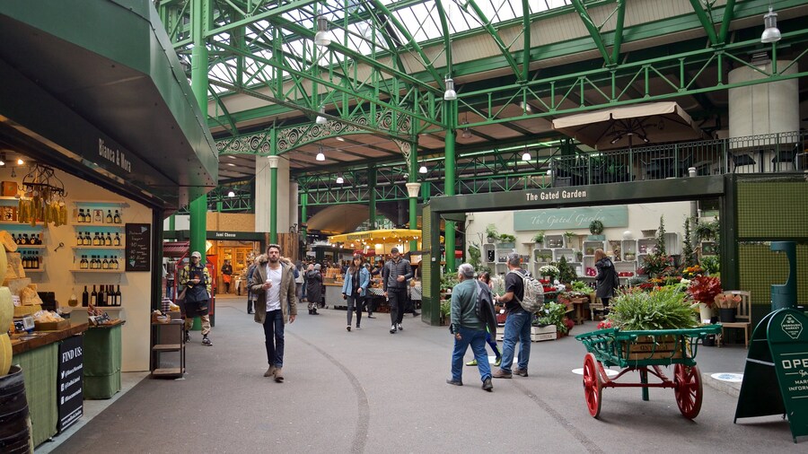 Interior view of Borough Market in London, featuring green ironwork and bustling food stalls.