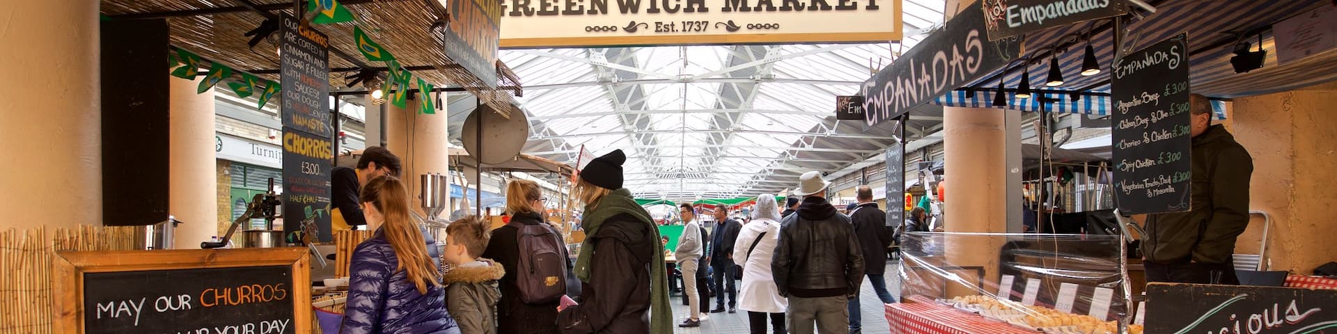 Greenwich Market featuring markets and signage as well as a small group of people