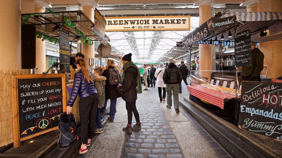 Greenwich Market mostrando mercati e segnaletica cosi come un piccolo gruppo di persone