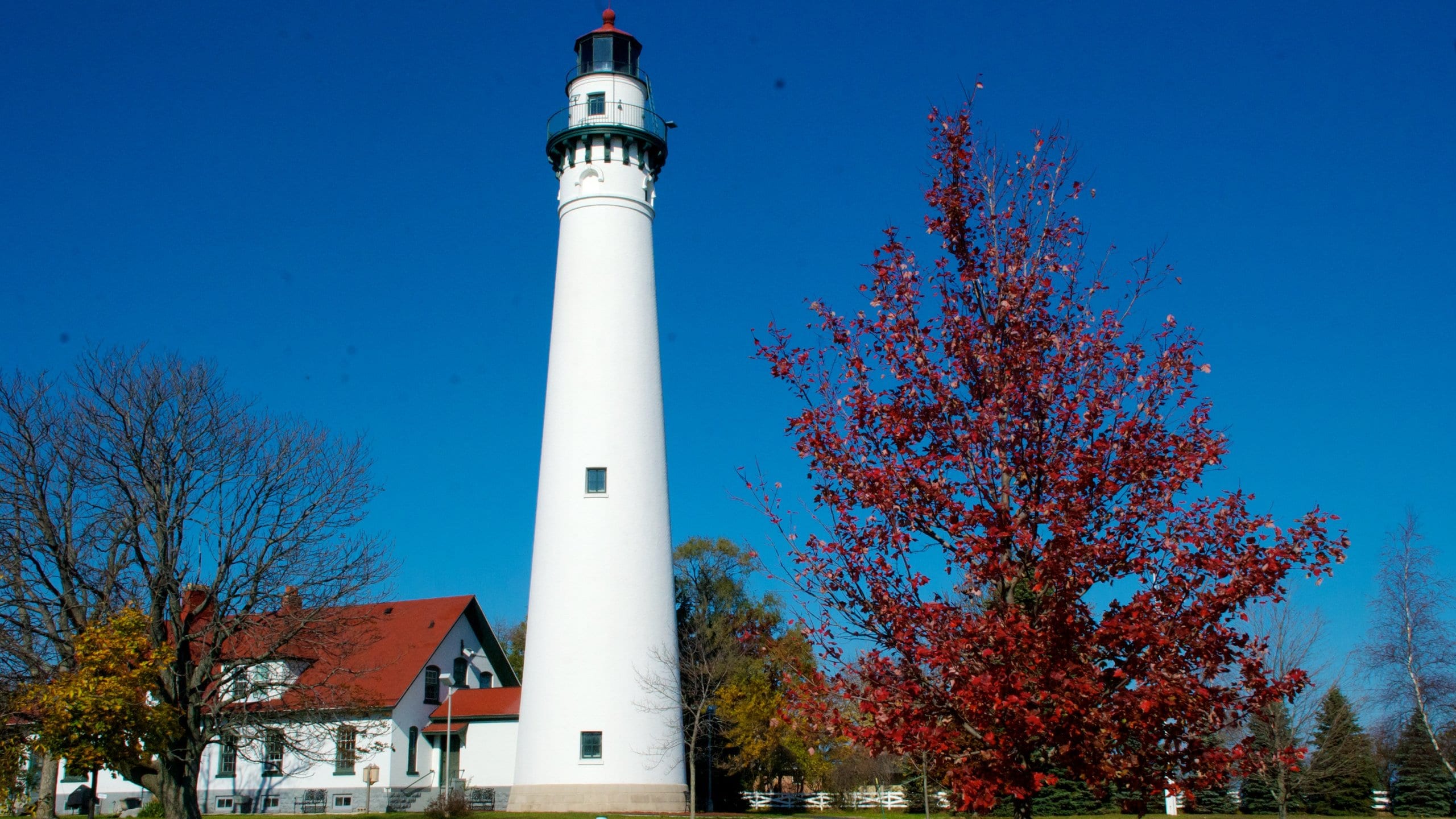 Wind Point Lighthouse que incluye hojas de otoño, un faro y patrimonio de arquitectura