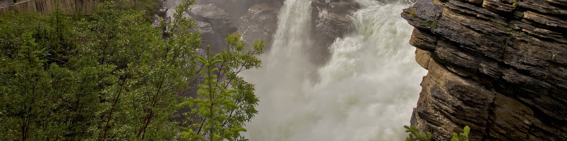 Athabasca Falls featuring a waterfall, landscape views and mist or fog