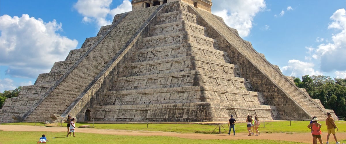 Chichen Itza featuring heritage architecture as well as a small group of people