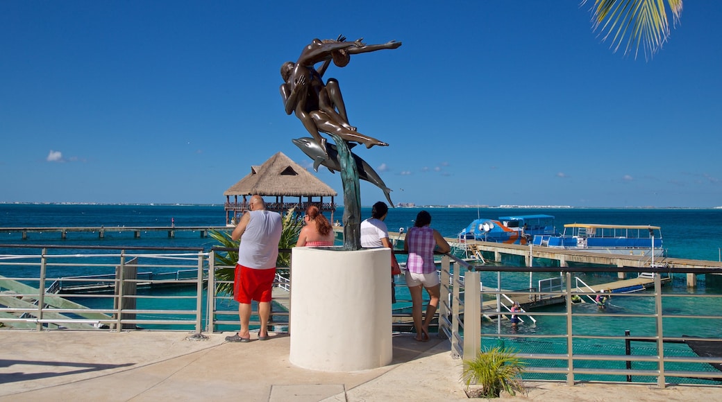 Dolphin Discovery que incluye arte al aire libre y vistas de una costa y también un grupo pequeño de personas