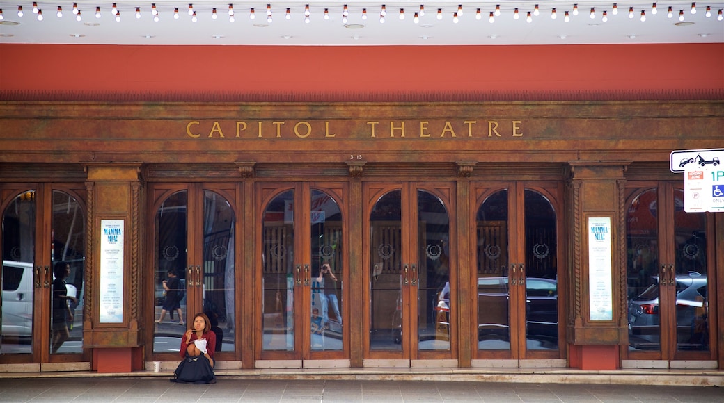 Teatro Capitol que incluye señalización y también una mujer